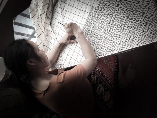 Femme appliquant la technique du batik hmong