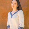 Woman wearing white organic cotton blouse and traditional blue weaves