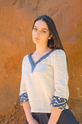 Femme portant blouse coton bio blanche et tissages traditionnels bleus