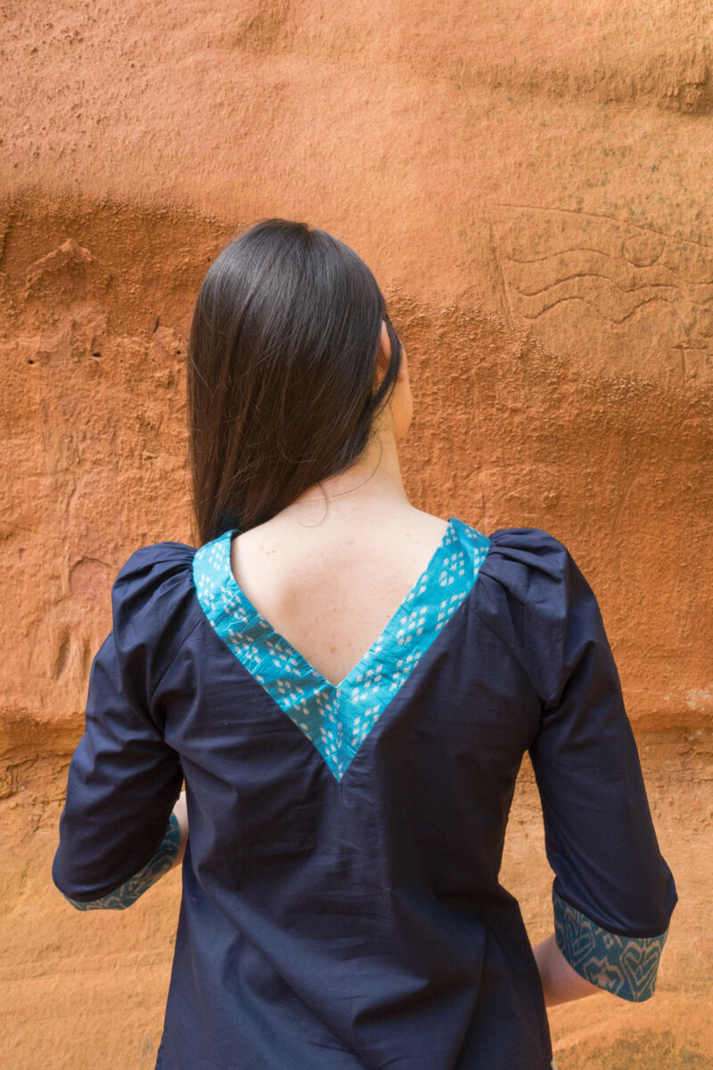 Woman from back wearing blue silk blouse detail