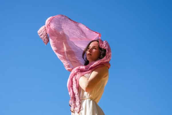 Woman in ethical white dress and pink silk scarf